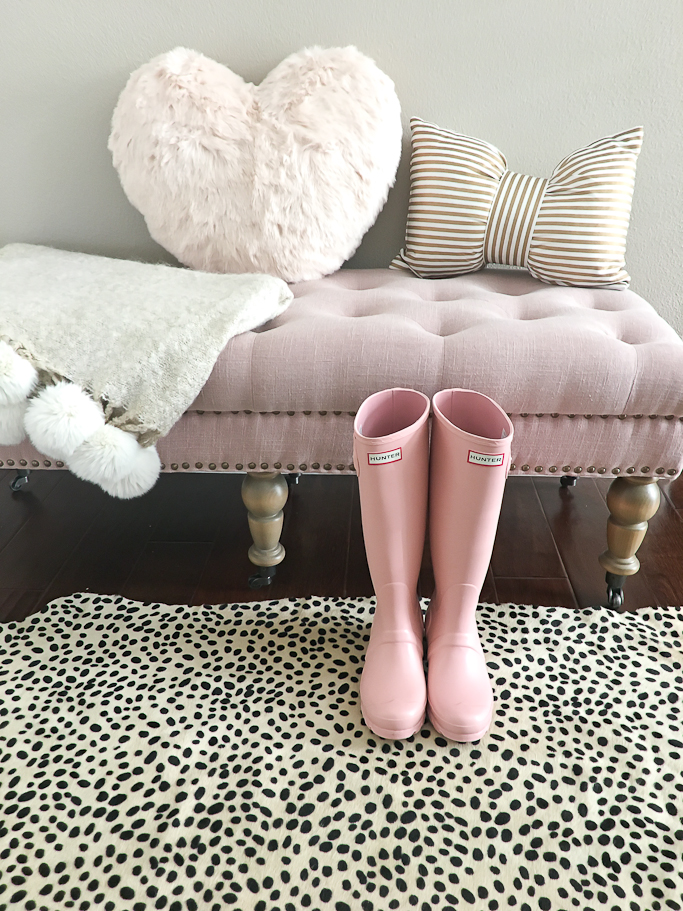 Pink Hunter boots, pink tufted bench, heart pillow, gold striped bow pillow, pom pom throw blanket, cheetah rug