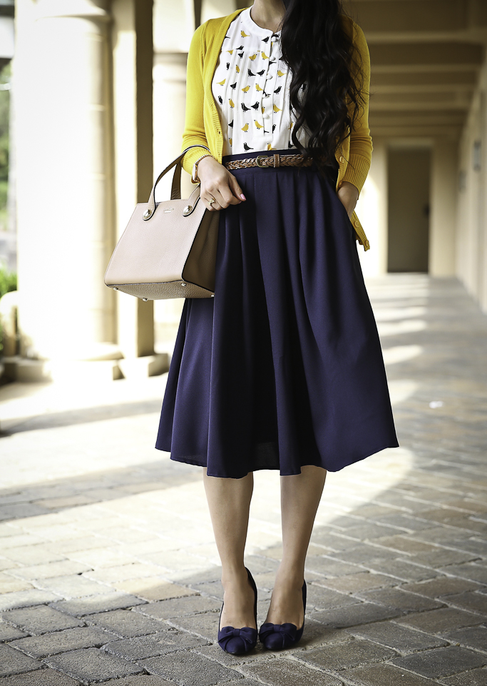 modest work outfit navy pleated skirt mustard cardigan bow pumps